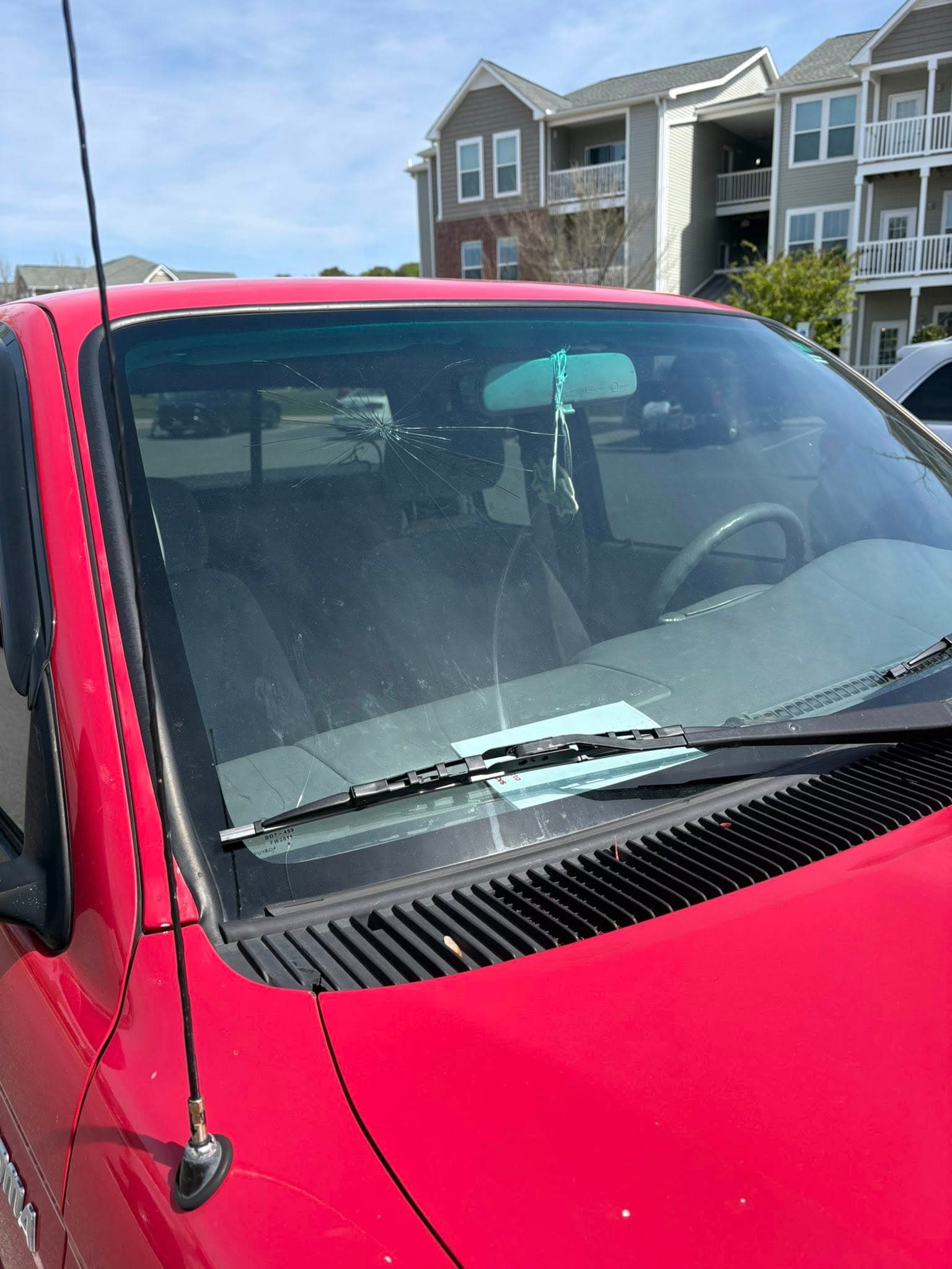 windshield replacement — red sedan — before